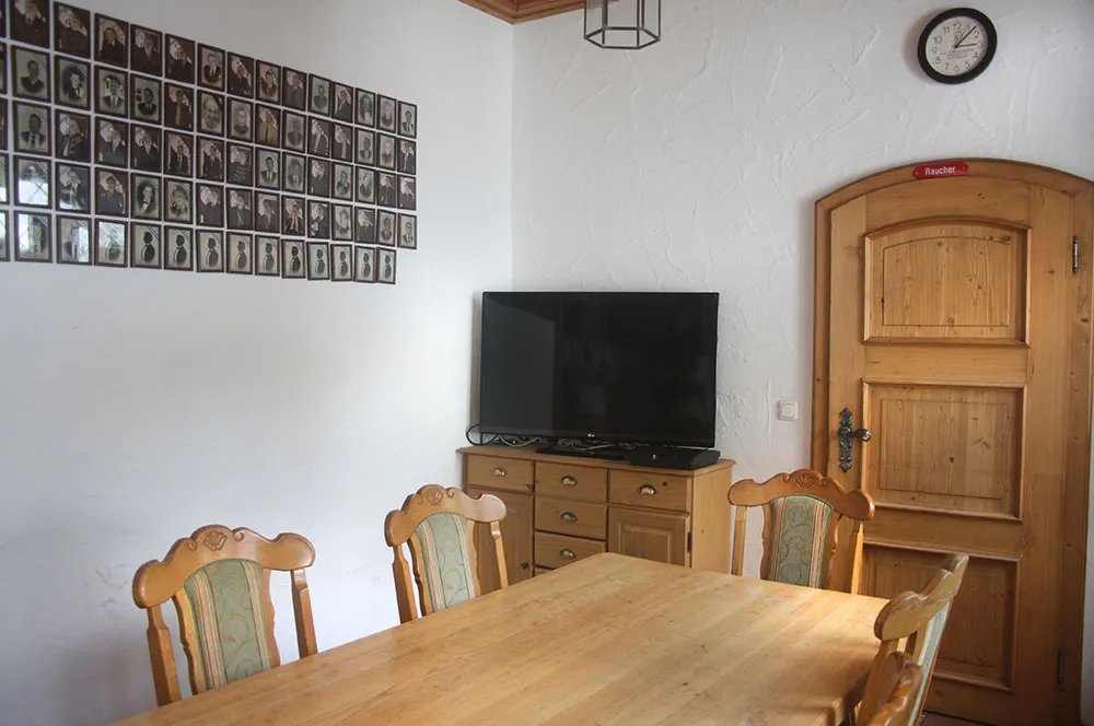 Bierstüble mit Holztisch, Fernseher und Fotowand