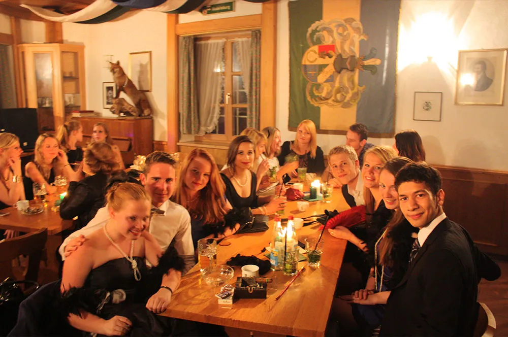 Gäste feiern an einem gedeckten Tisch auf dem Haus